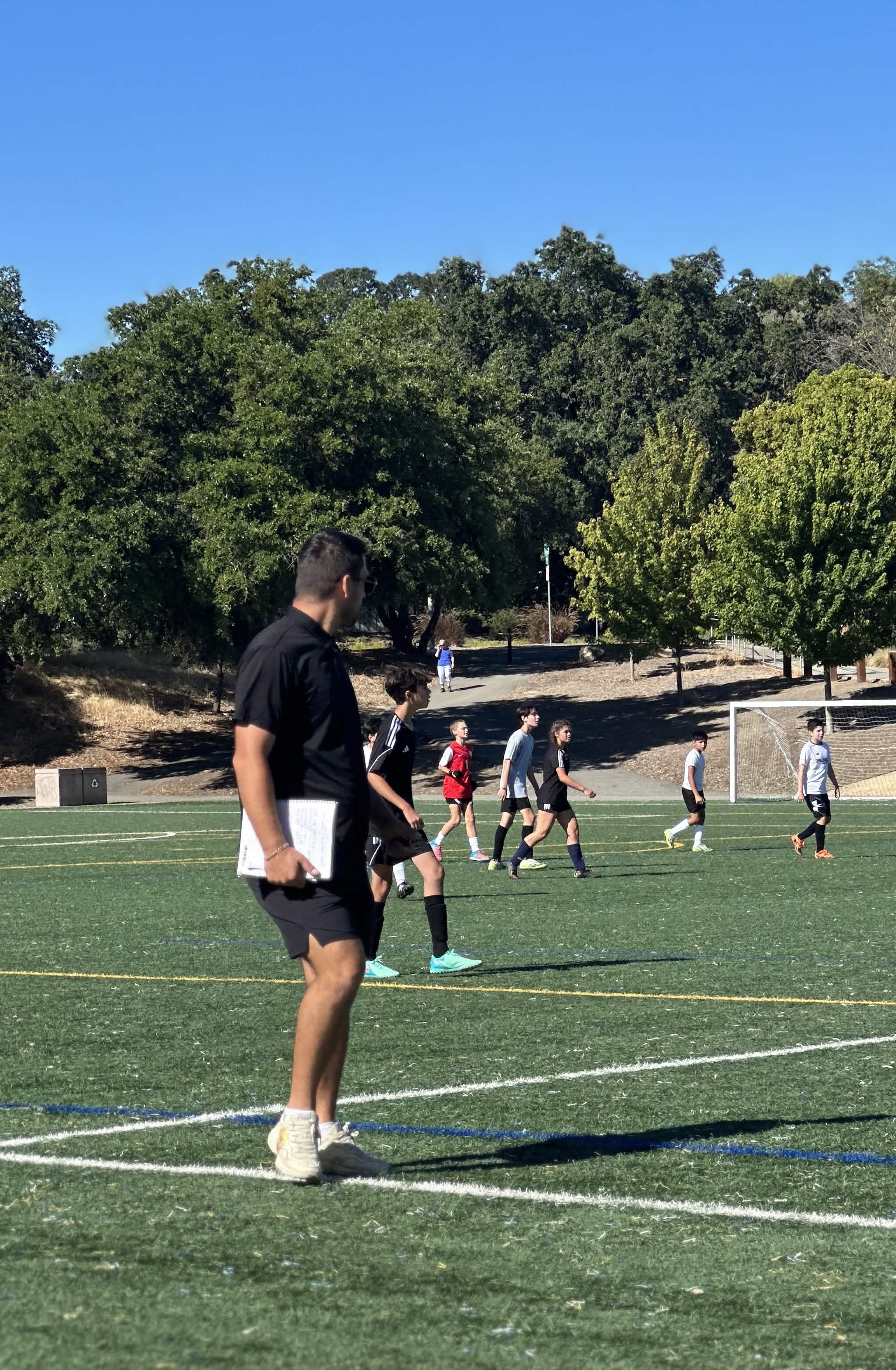 Coach watching group training on the field