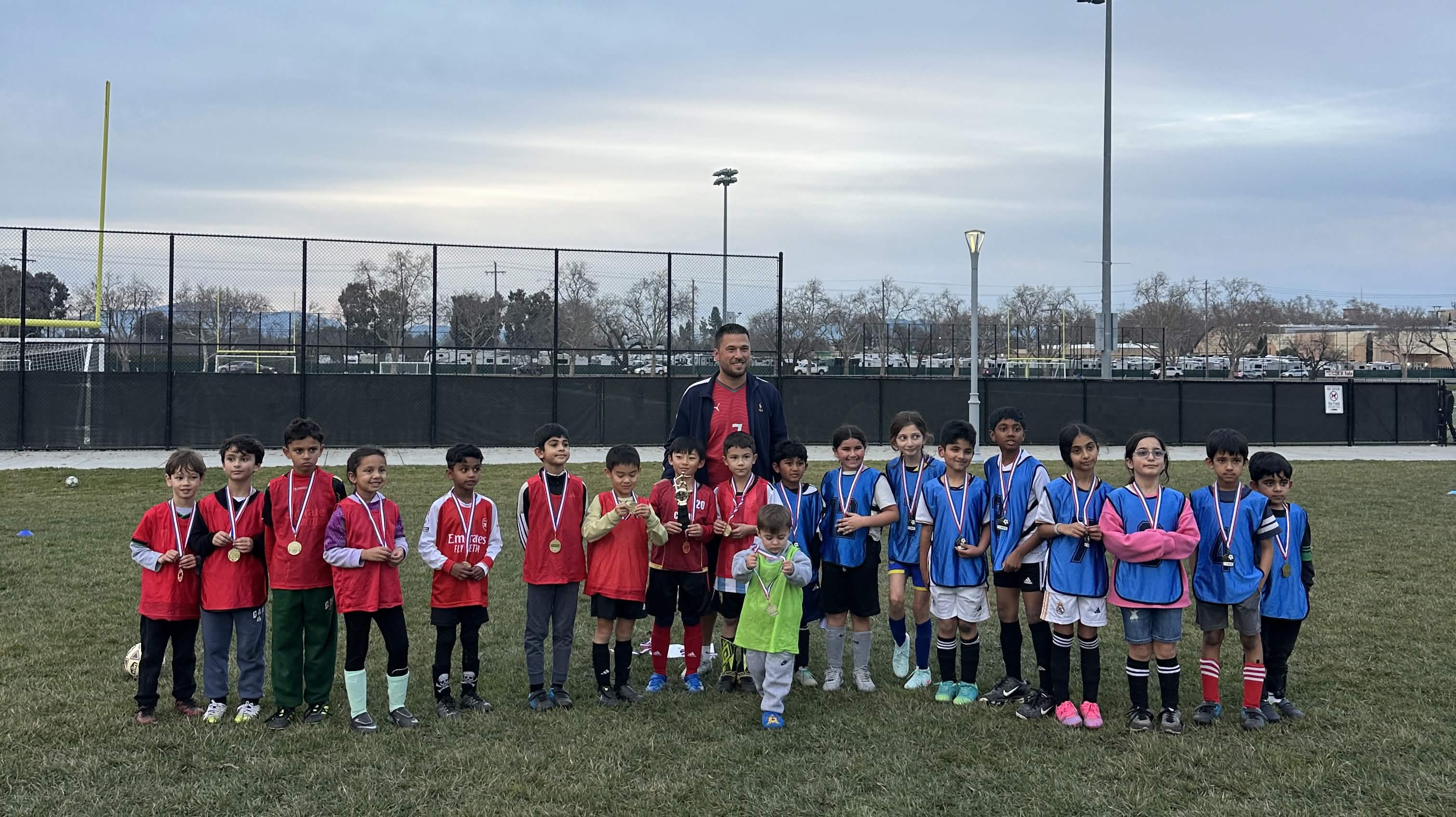 Coach with kids receiving medals at award ceremony